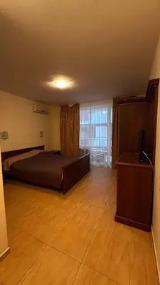 a bedroom with a bed and a television on a wooden floor at Sveti Vlas, Paradise Dreams Apartment in Sveti Vlas