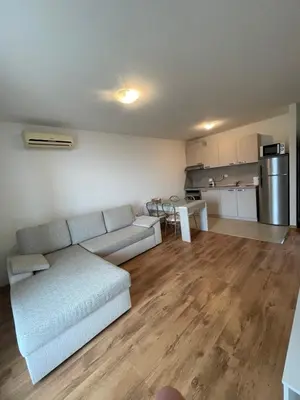 a living room with a couch and a kitchen at Fortuna Cape 4 apartment in Byala
