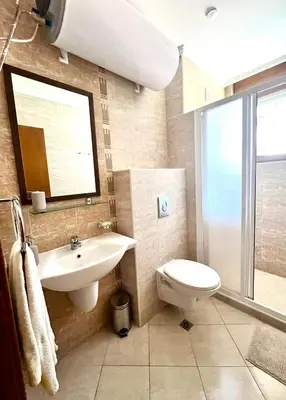 a bathroom with a sink and a toilet and a window at Amara Holiday Santa Marina, Sozopol in Sozopol