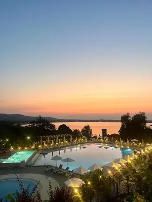 a view of a pool with umbrellas at night at Amara Holiday Santa Marina, Sozopol in Sozopol