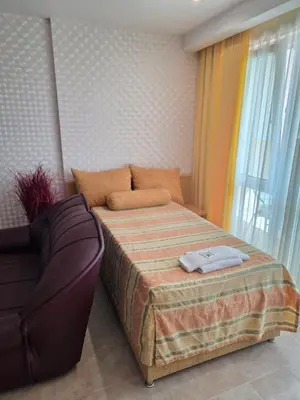 a small bedroom with a bed and a couch at Apartament Hotel Miramar Palace in Sunny Beach