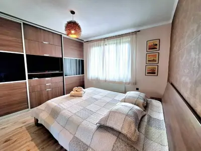 a bedroom with a large bed and a tv at Veneto Apartment in Varna City