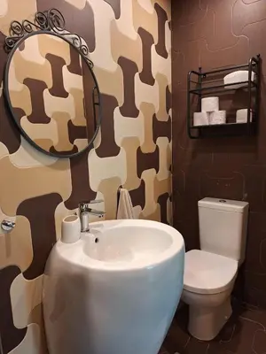 a bathroom with a sink and a toilet and a mirror at Veneto Apartment in Varna City