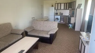 a living room with two couches and a kitchen at Apartments complex Breeze Sunny beach - Апартаменти комплекс Бриз Слънчев бряг in Bŭnzareto
