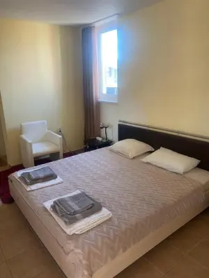 a bedroom with a bed with two towels on it at Apartments complex Breeze Sunny beach - Апартаменти комплекс Бриз Слънчев бряг in Bŭnzareto