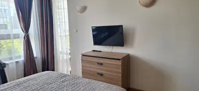 a bedroom with a bed and a television on a dresser at Royal Dreams Apartments, Sunny Beach in Sunny Beach