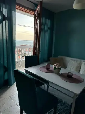 a living room with a table and a view of the ocean at Villa Nikoleta in Sveti Vlas