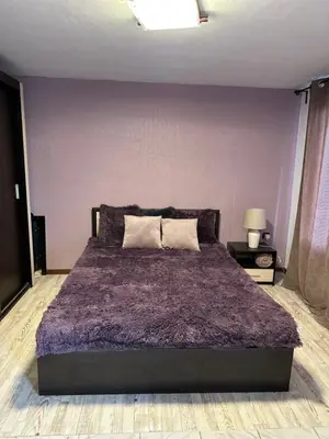 a bedroom with a large bed with a purple wall at Villa Nikoleta in Sveti Vlas
