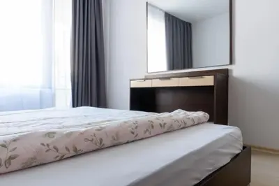 a bedroom with a large bed and a mirror at Делукс Апартамент Лазур Поморие in Pomorie