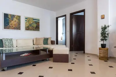 a living room with a couch and a table at Делукс Апартамент Лазур Поморие in Pomorie