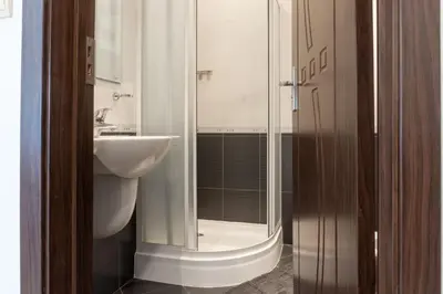 a bathroom with a glass shower and a sink at Делукс Апартамент Лазур Поморие in Pomorie