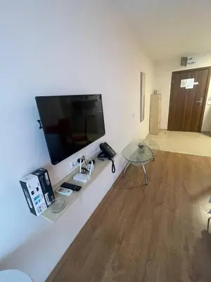 a living room with a tv and a glass table at Premier Fort Beach Hotel ! in Sveti Vlas