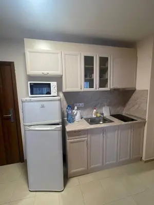 a kitchen with white cabinets and a white refrigerator at Premier Fort Beach Hotel ! in Sveti Vlas