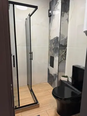 a bathroom with a shower with a black toilet at La Terrassa 7 in Burgas City