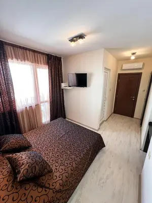 a hotel room with a bed and a large window at Kaleya House in Chernomorets