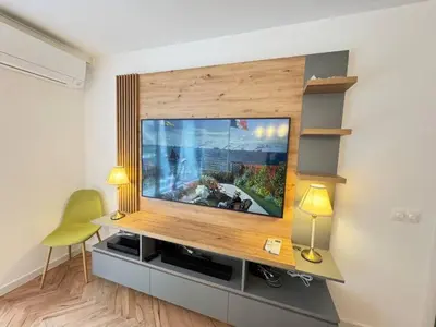 a living room with a flat screen tv on a wall at Apartament A 2BD in Burgas City