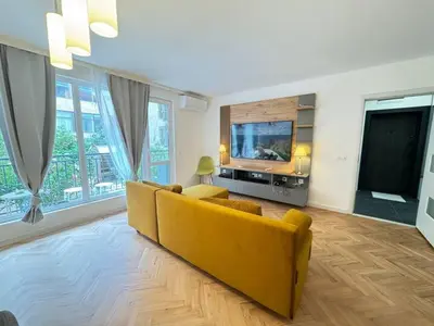 a living room with a yellow couch and a tv at Apartament A 2BD in Burgas City