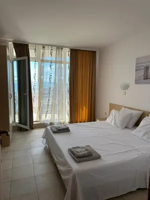 a bedroom with a large white bed with towels on it at Vega View in Sveti Vlas