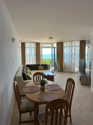 a living room with a table and a couch at Vega View in Sveti Vlas