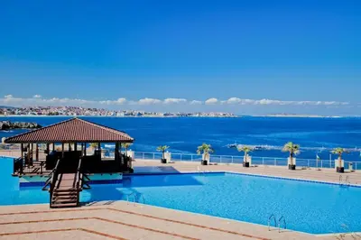 a swimming pool with the ocean in the background at Sozopolis Sunset Apartment with sea view in Sozopol
