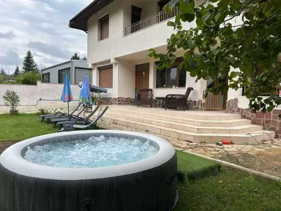 a hot tub in a yard in front of a house at Villa Amity in Varna City