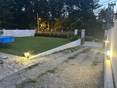 a backyard with a yard with a fence and a table and a bench at Villa Amity in Varna City