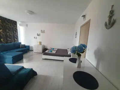a living room with a blue couch and a vase of flowers at Sunny Day 6 in Sunny Beach