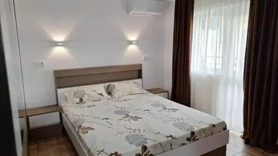 a bedroom with a bed with a floral comforter at Апартамент ReLax Китен in Kiten