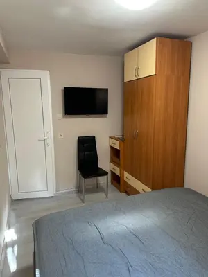 a bedroom with a bed and a cabinet and a chair at Rumen Apartment in Nesebar
