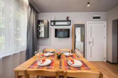 a dining room table with plates and wine glasses at Top Central Flats with Style in Varna City