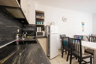 a kitchen with a black counter top and a white refrigerator at Marea 1 in Pomorie