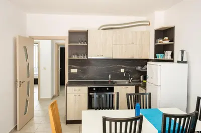 a kitchen with wooden cabinets and a white refrigerator at Marea 1 in Pomorie