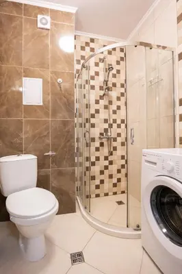 a bathroom with a toilet and a shower and a washing machine at Marea 1 in Pomorie
