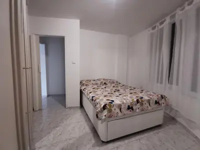 a bedroom with a bed in a white room at Мезонет в Гръцката Махала in Varna City