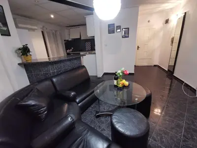 a living room with a leather couch and a table at Мезонет в Гръцката Махала in Varna City