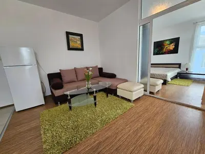 a living room with a couch and a table at Odisei Large Studio in Nesebar