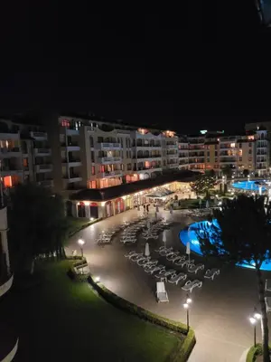a view of a hotel with a pool at night at Royal Sun Apartment in Sunny Beach