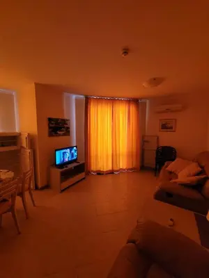 a living room with a couch and a television at Royal Sun Apartment in Sunny Beach