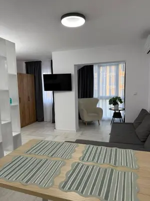 a living room with a couch and a television at Sveti Vlas, Rodopi Bay Residence in Sveti Vlas