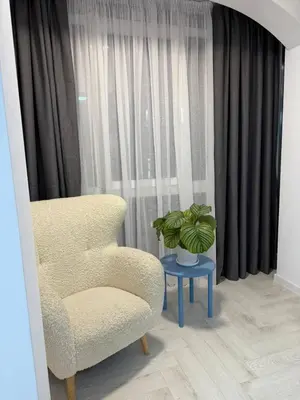 a chair and a table with a plant in front of a window at Sveti Vlas, Rodopi Bay Residence in Sveti Vlas