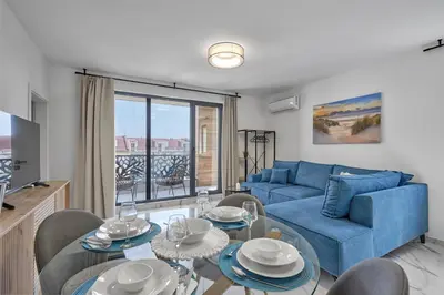 a living room with a blue couch and a table at SEA SHELL Apartment in Sozopol