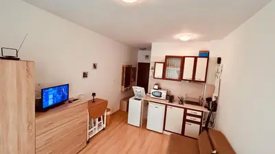 a small room with a kitchen with a desk and a television at Sunny Day 6 Studio 11 in Sunny Beach