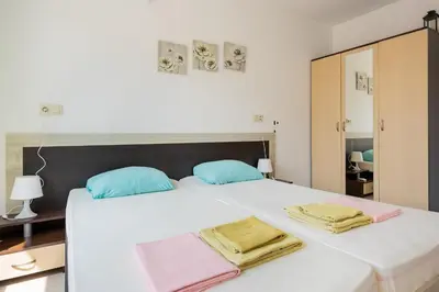 a bedroom with a white bed with towels on it at Marea 2 in Pomorie