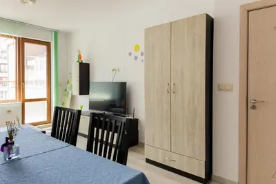 a dining room with a table and a large cabinet at Marea 2 in Pomorie