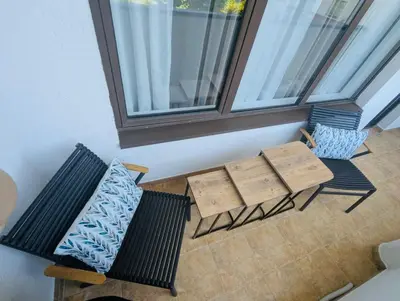 two benches and tables in a room with a window at VODENICATA 5B4 Apartment Sveti Vlas in Sveti Vlas