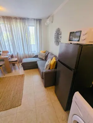 a living room with a refrigerator and a couch at VODENICATA 5B4 Apartment Sveti Vlas in Sveti Vlas