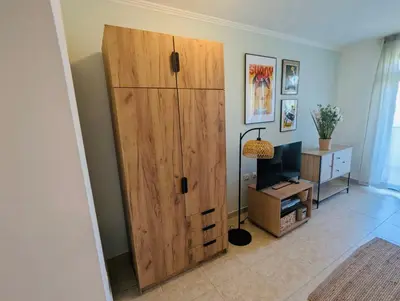 a large wooden cabinet in a living room with a television at VODENICATA 5B4 Apartment Sveti Vlas in Sveti Vlas