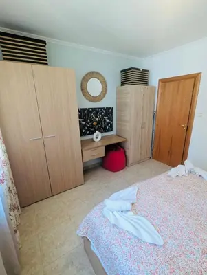a bedroom with a bed and some wooden cabinets at VODENICATA 5B4 Apartment Sveti Vlas in Sveti Vlas