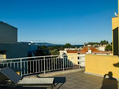 a balcony with a table and a chair on a building at AQUA BLUE APARTMENTS 38 Penthouse Sunny Beach in Sunny Beach