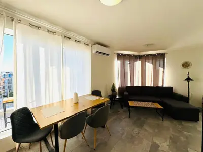 a living room with a table and a couch at AQUA BLUE APARTMENTS 38 Penthouse Sunny Beach in Sunny Beach